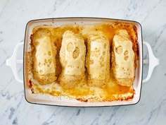 four pieces of bread in a casserole dish on a marble counter top,