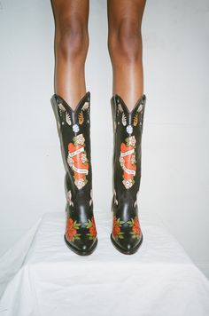 The Brother Vellies Doodle Boots have been a long-time fan favorite. They are one-of-a-kind works of art handmade and hand painted with love by Artisans in Mexico. In honor of Women’s History Month, Brother Vellies is releasing a limited collection of custom Doodles, featuring three new Doodle Boots and two new Doodl Cowboy Boots And Bathing Suits, Brother Vellies Shoes, Custom Made Cowboy Boots, Western Chic Fashion Dressy, Art On Clothes Paint, Cool Cowboy Boots, Cowgirl Boots Art, Aurora James, Eccentric Shoes