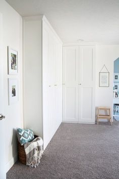 an empty room with white walls and carpet