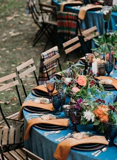 a table set up with blue cloths and flowers