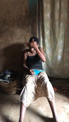 a woman sitting on the floor in front of a window