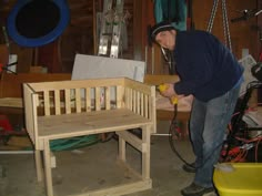 a man working on a wooden bench in a garage