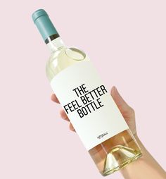 a person holding a bottle of wine with the label saying, the feel better bottle