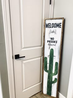 a welcome sign in front of a door with a cactus painted on it and the words, welcome cash no pricks allowed