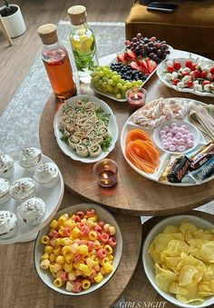 a table filled with plates and bowls of food on top of a wooden table next to a tv