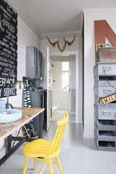 a yellow chair sitting in front of a wooden table with lots of crates on it