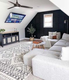 a living room filled with furniture and a flat screen tv mounted to the side of a wall