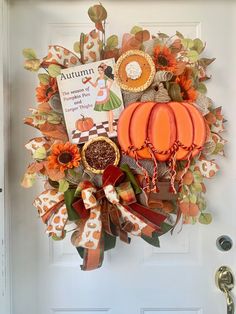 an autumn wreath with pumpkins and other items hanging on the front door for fall