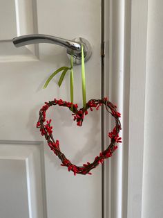 a heart shaped wreath hangs on the front door