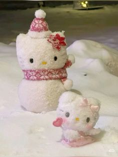 two stuffed animals in the snow one is white and the other is pink with a red bow