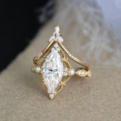 a close up of a ring with a diamond and pearls on the bottom, surrounded by feathers