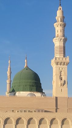 a large white building with a green dome on it's roof and two minages