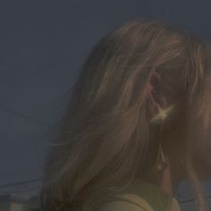 a woman with long hair and earrings on her ear