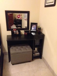 a bedroom with a vanity, mirror and foot stool