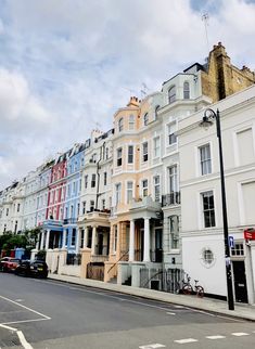 a row of multi - colored buildings on the side of a street