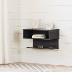 a shelf with two books on top of it in front of a wall mounted clock