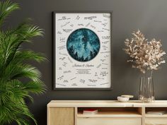 a vase with some flowers in it next to a wall mounted art print on the wall