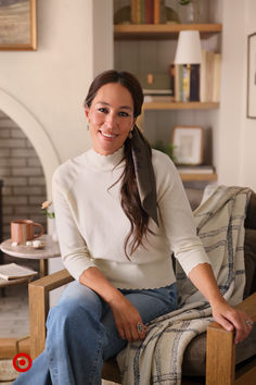 a woman sitting in a chair smiling at the camera