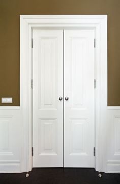 an empty room with two white doors and brown walls