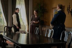 three people standing around a dining room table