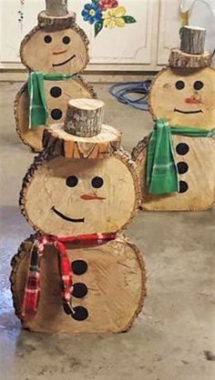 three snowmen made out of logs with hats and scarves