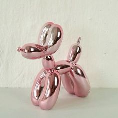 a pink balloon dog sitting on top of a white table