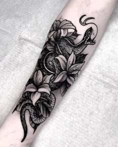 a black and white flower tattoo on the arm