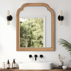 a bathroom vanity with a mirror above it and two black faucets on the counter