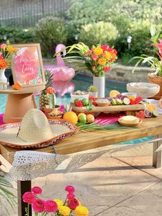 the table is set up with flowers, fruit and other items for an outdoor party