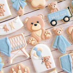 decorated cookies with teddy bears and baby items on a white table top, including a blue truck