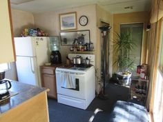 a kitchen with an oven, refrigerator and coffee pot on the stove top in it