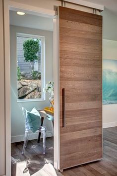 an open door leading to a dining room and living room with a painting on the wall