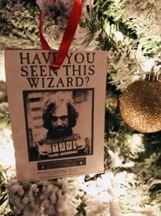 a newspaper ornament hanging from a christmas tree with snow on it and a red ribbon