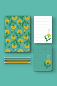 a notepad, notebook and pencils on a blue background with dandelions