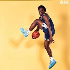 a man is jumping in the air with a basketball on his feet and wearing blue shoes