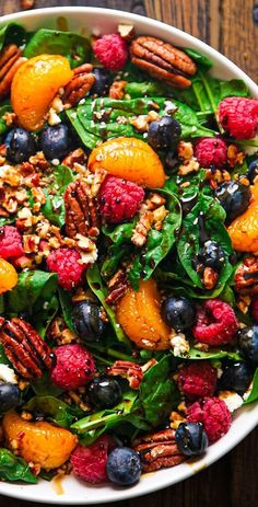 a white bowl filled with fruit and nuts