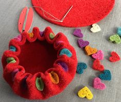 a red heart shaped object next to some crochet hearts