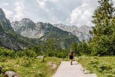 a man walking down a trail in the mountains