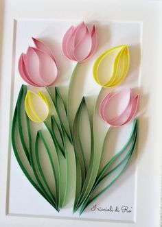 some paper flowers are in a white frame