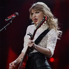 taylor swift performing on stage with her guitar