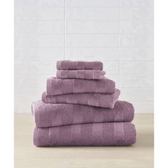 towels stacked on top of each other in front of a tiled wall