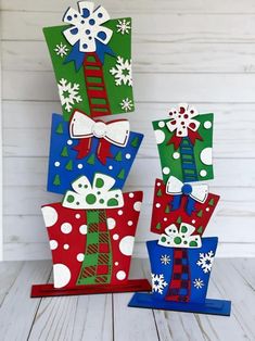 three christmas gift boxes with bows and snowflakes are stacked on top of each other