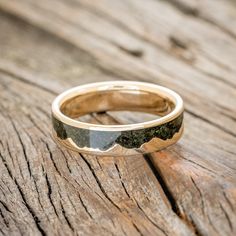 a close up of a wedding ring on a wooden table with wood grained surface