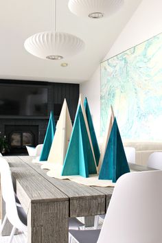 a dining room table with white chairs and blue mountains on the top of each one