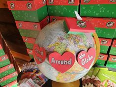 a globe with hearts on it sitting in front of boxes