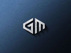 the letters g and m are made out of silver foil on a dark blue background