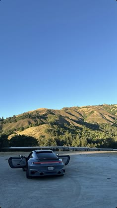 a car parked in a parking lot with mountains in the background