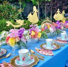 the table is set with plates, cups, and saucers for an elegant tea party