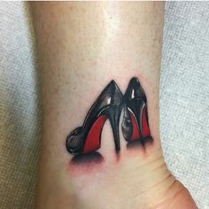 a woman's foot with a pair of high heeled shoes tattoo on it