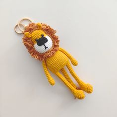 a crocheted lion keychain hanging on a white surface